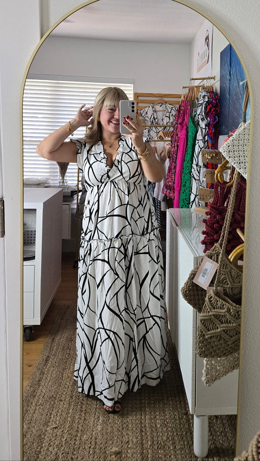 Discover our stunning black and white maxi dress with ruffle trim and vein-inspired abstract print. Perfect for travel or celebrations, this versatile piece features a comfortable lining for all-day wear. Elevate your style effortlessly!