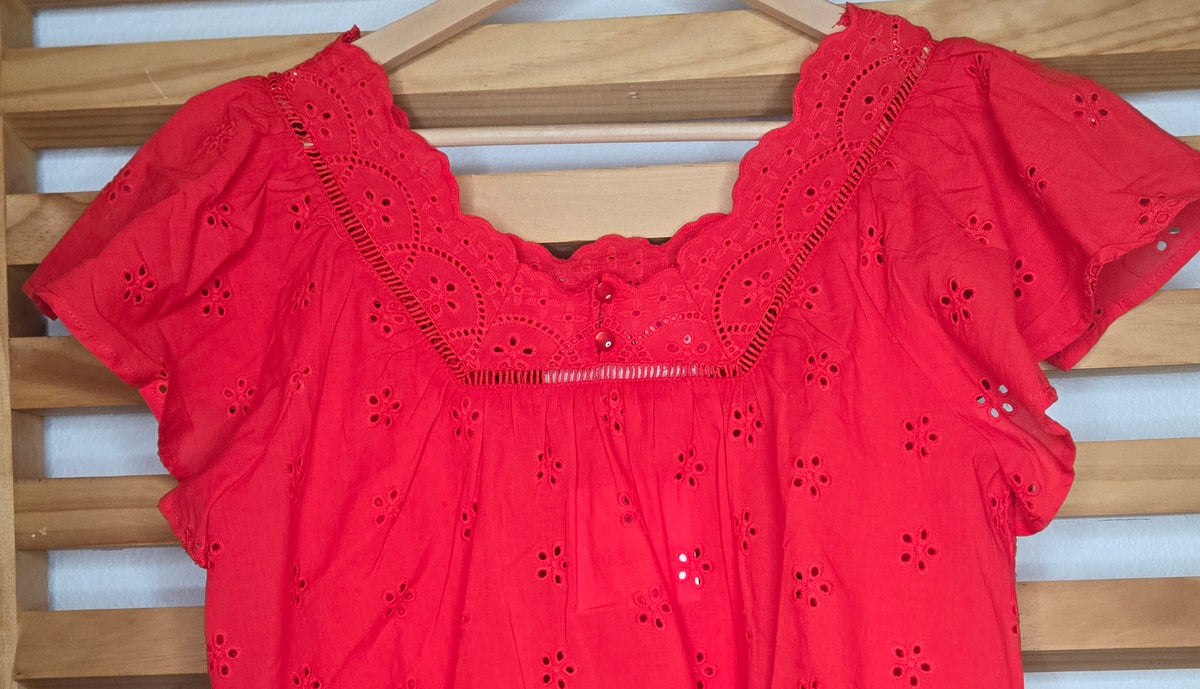 Women's red eyelet blouse with floral embroidery and short flutter sleeves.