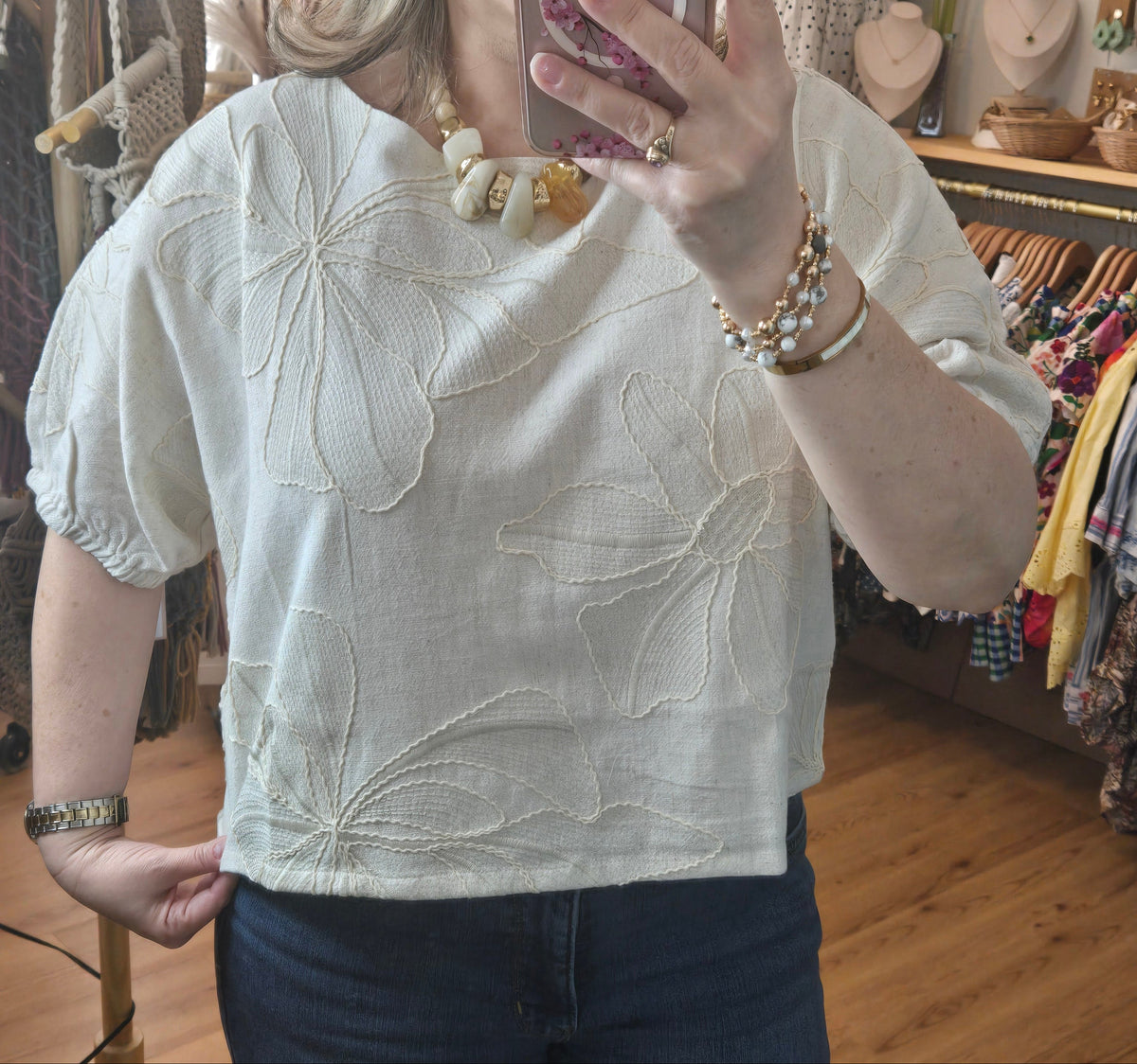 Beige linen-blend top with floral embroidery, featuring short dolman sleeves with elastic cuffs and a soft inner lining