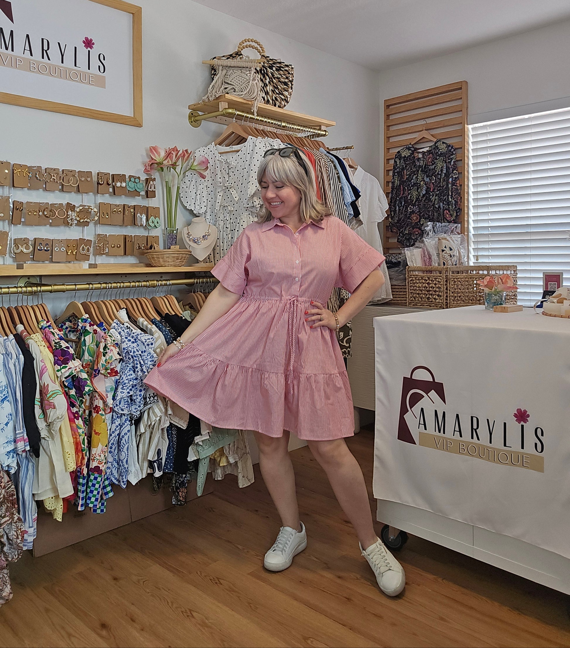Red striped cotton dress with collared neckline, rolled short sleeves, button front detail, tiered skirt, ruffled hem, and adjustable tie waist.