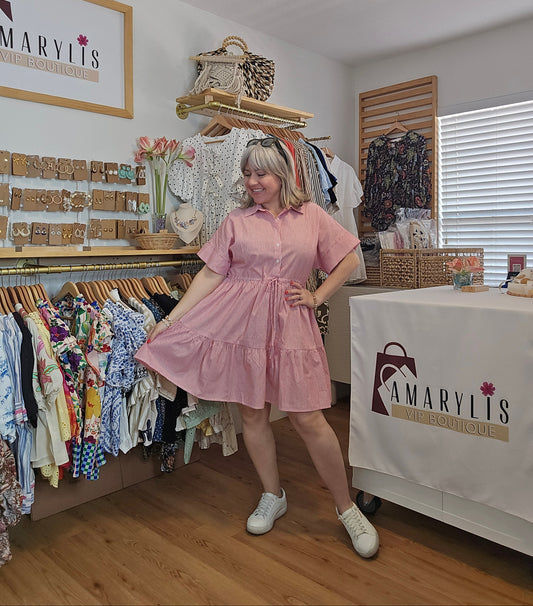 Red striped cotton dress with collared neckline, rolled short sleeves, button front detail, tiered skirt, ruffled hem, and adjustable tie waist.