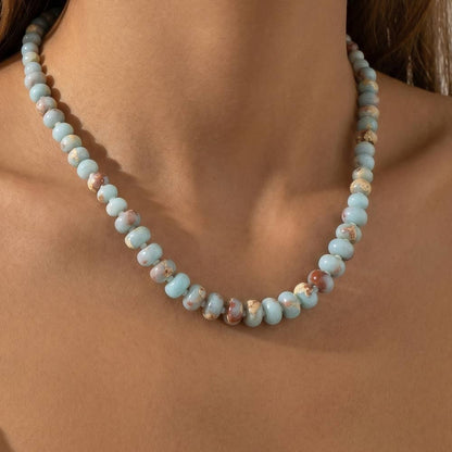 Semi-precious gemstone necklace featuring smooth sky-blue rondelle beads with natural brown matrix accents and delicate spacer beads.