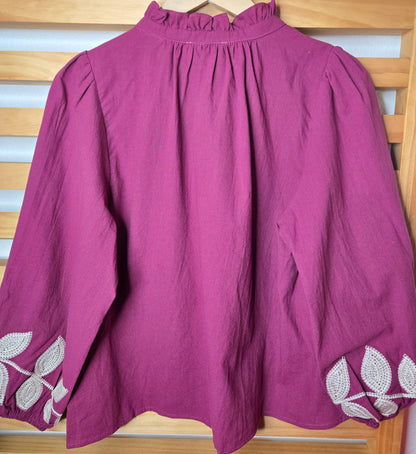 Magenta cotton blouse with floral embroidery, button-down front, and long sleeves