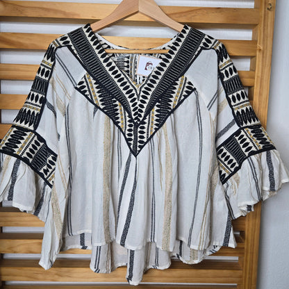 V-neck blouse with black embroidery details, flutter sleeves, and vertical stitched accents for a flattering silhouette.
