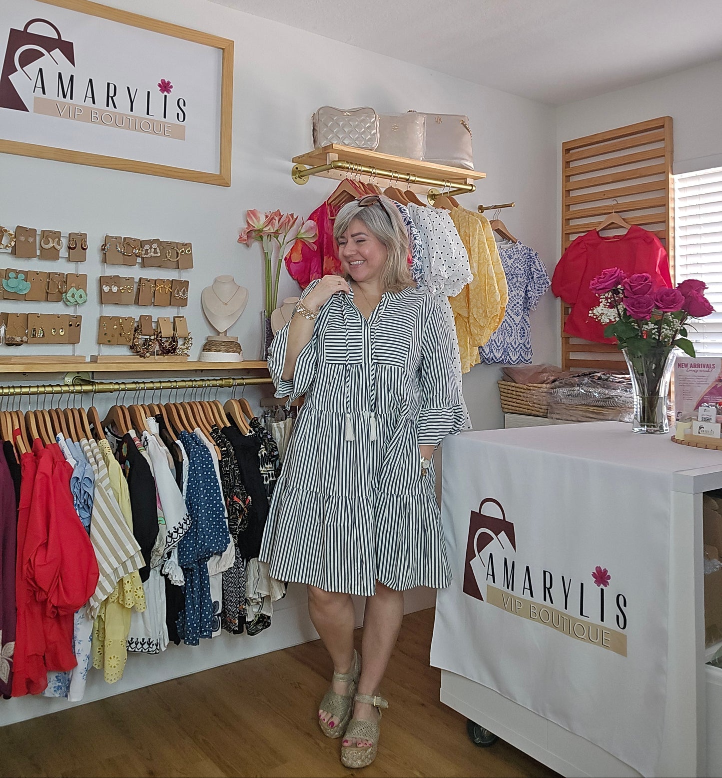 Navy striped cotton babydoll dress with bell sleeves, tassel tie neckline, relaxed fit silhouette, and functional side pockets.
