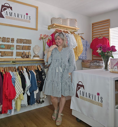 Navy striped cotton babydoll dress with bell sleeves, tassel tie neckline, relaxed fit silhouette, and functional side pockets.