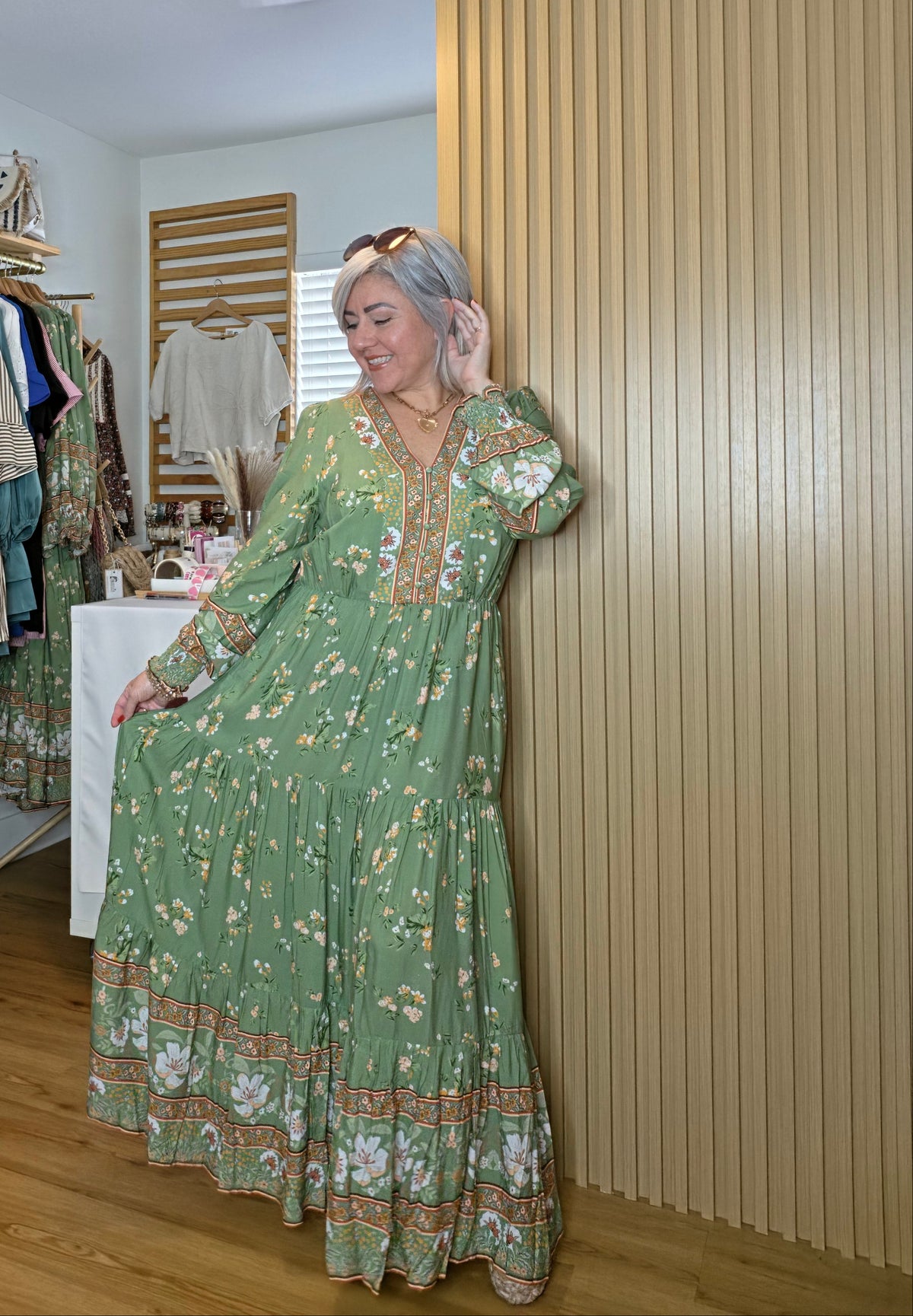 Floral print maxi dress featuring a contrasting border print, split V-neckline, button-front bodice, elastic empire waist, long sleeves with smocked cuffs, and tiered skirt.