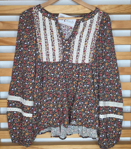 Women's floral print peplum blouse with lace accents on the front and sleeves and voluminous balloon sleeves in autumn colors