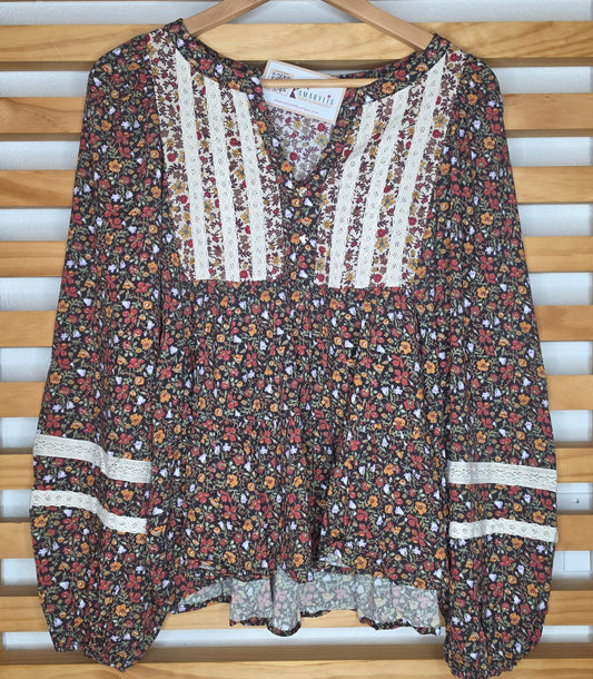 Women's floral print peplum blouse with lace accents on the front and sleeves and voluminous balloon sleeves in autumn colors