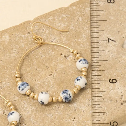 floral earrings, ceramic jewelry, teardrop earrings, metallic beads, boho chic, statement accessories, feminine style