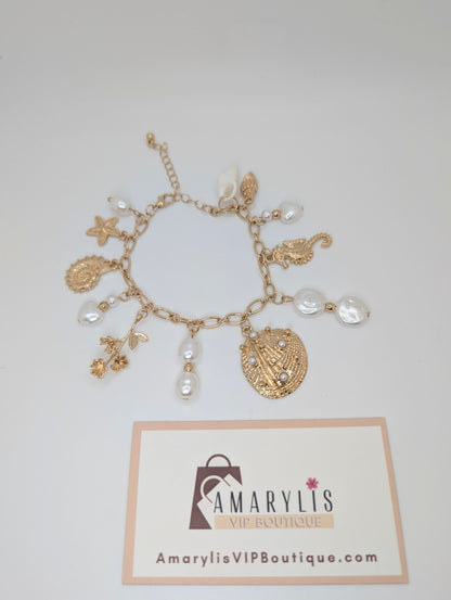 Gold charm bracelet with pearls on a white background, featuring Amarylis VIP Boutique logo.
