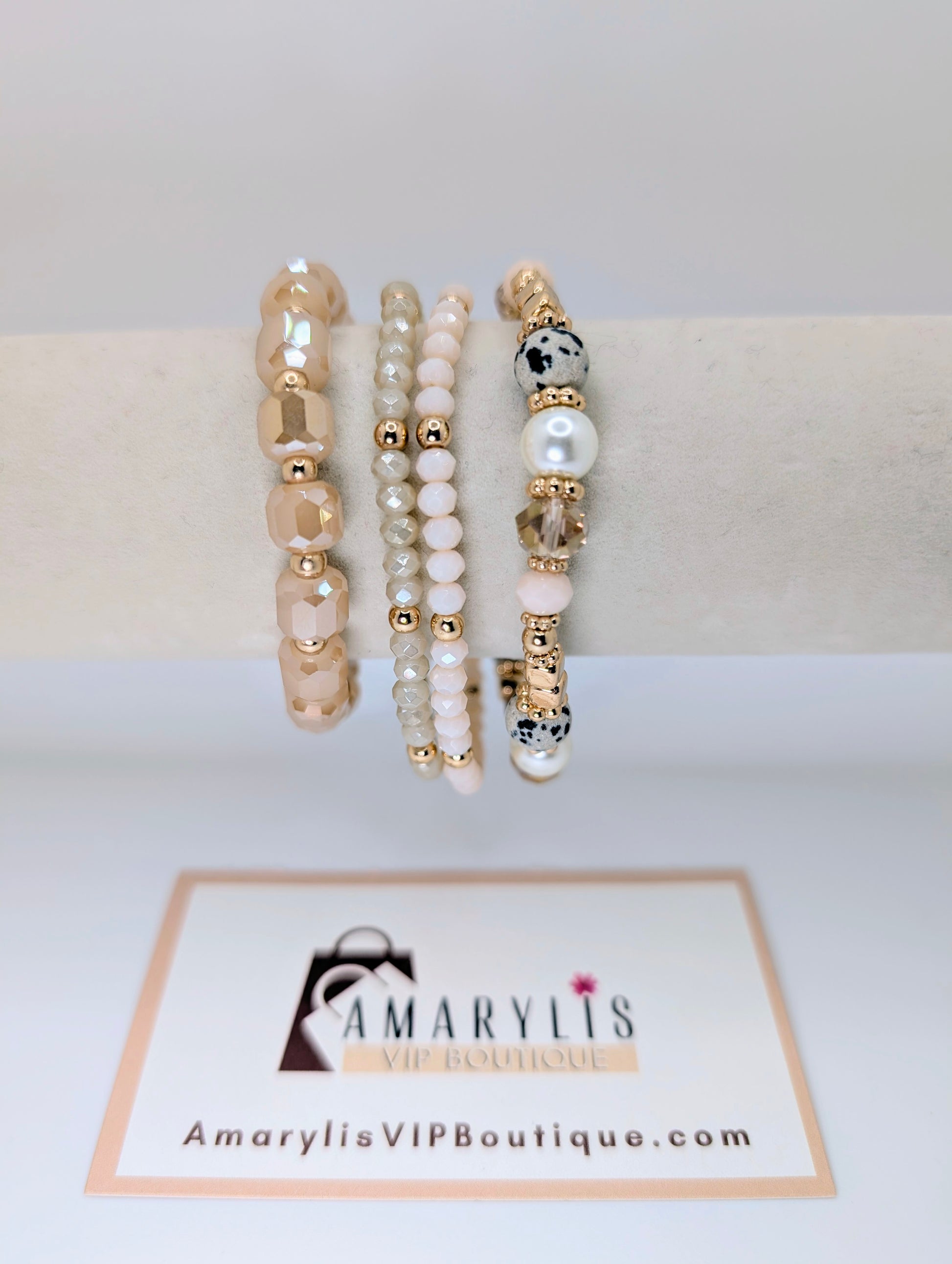 Set of beaded bracelets on a white surface with 'Amarylis VIP Boutique' branding.