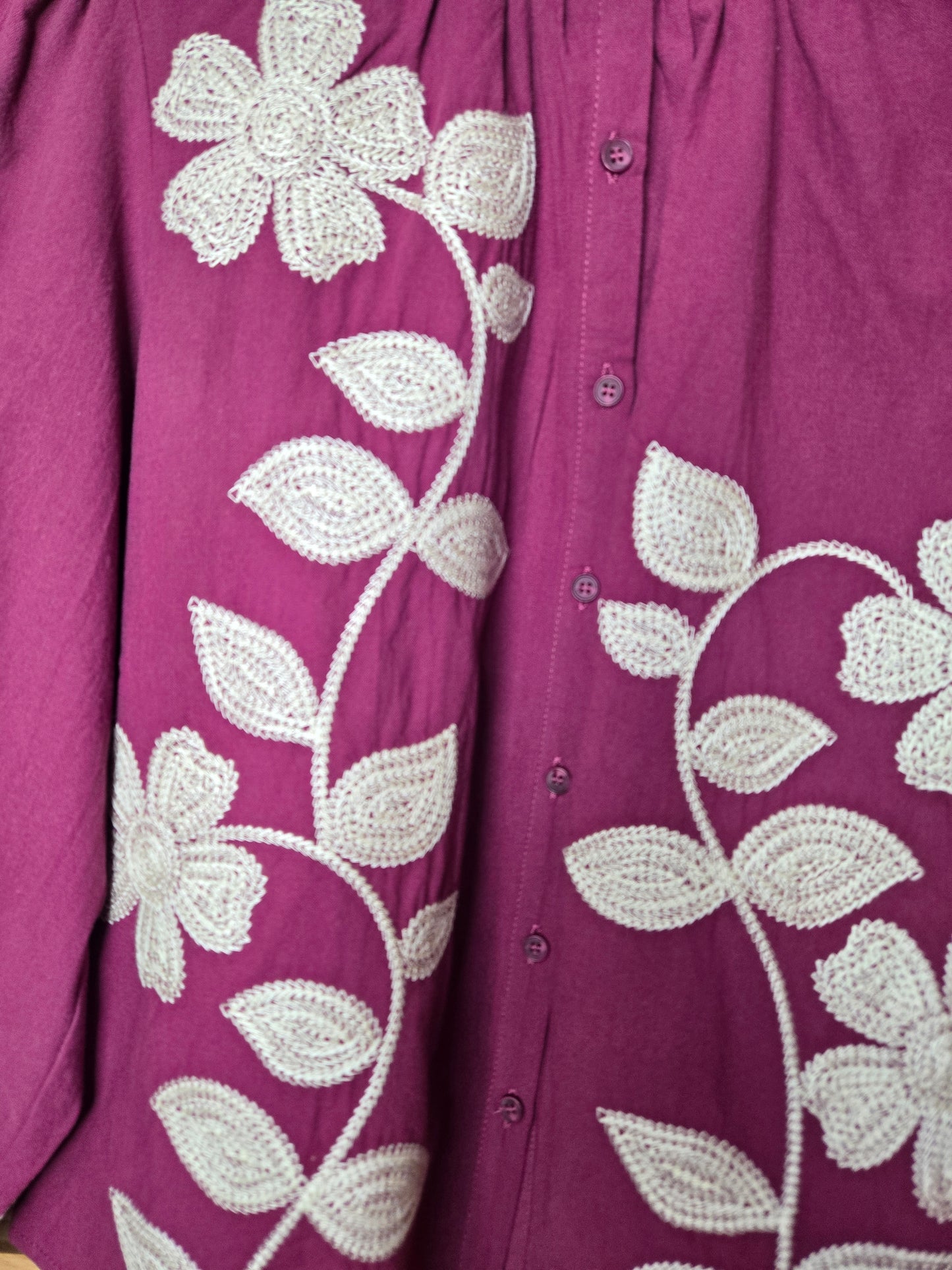 Magenta cotton blouse with floral embroidery, button-down front, and long sleeves
