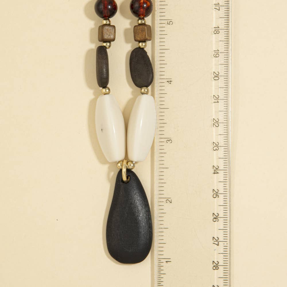 A timeless wood bead necklace with a graceful teardrop pendant, designed to bring natural beauty and effortless elegance to your wardrobe.