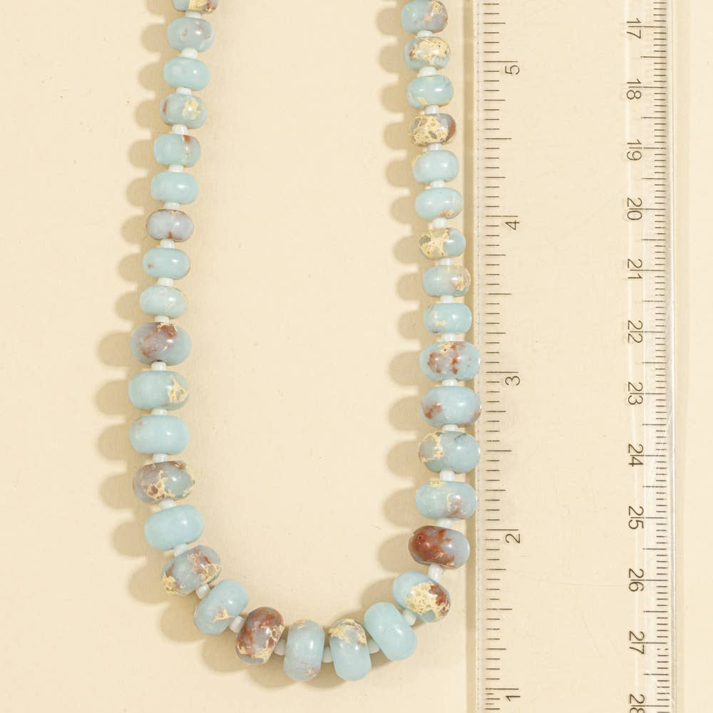 Semi-precious gemstone necklace featuring smooth sky-blue rondelle beads with natural brown matrix accents and delicate spacer beads.