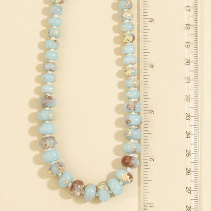 Semi-precious gemstone necklace featuring smooth sky-blue rondelle beads with natural brown matrix accents and delicate spacer beads.