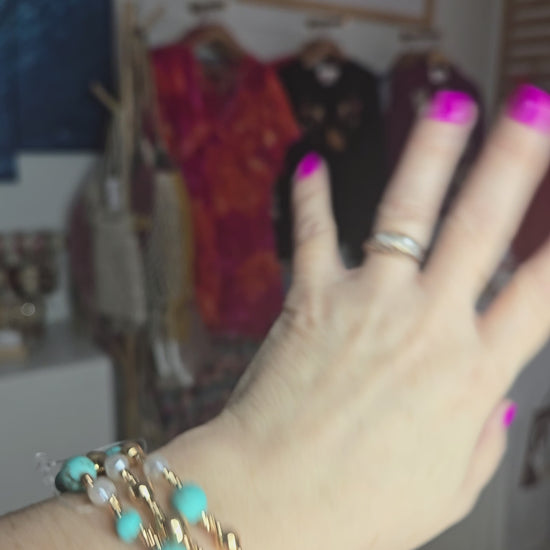 Turquoise stone, metallic, and pearl beaded bracelet set with layered design and textured detailing.