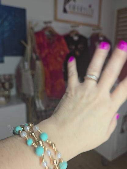 Turquoise stone, metallic, and pearl beaded bracelet set with layered design and textured detailing.