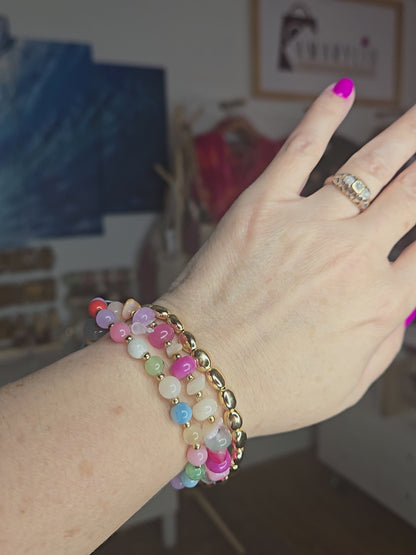 Metallic stone and multicolor beaded bracelet set featuring pearl accents and layered design details.