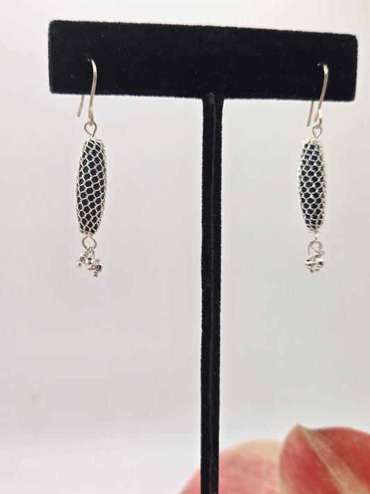 Red stone dangle earrings wrapped in metallic wire.