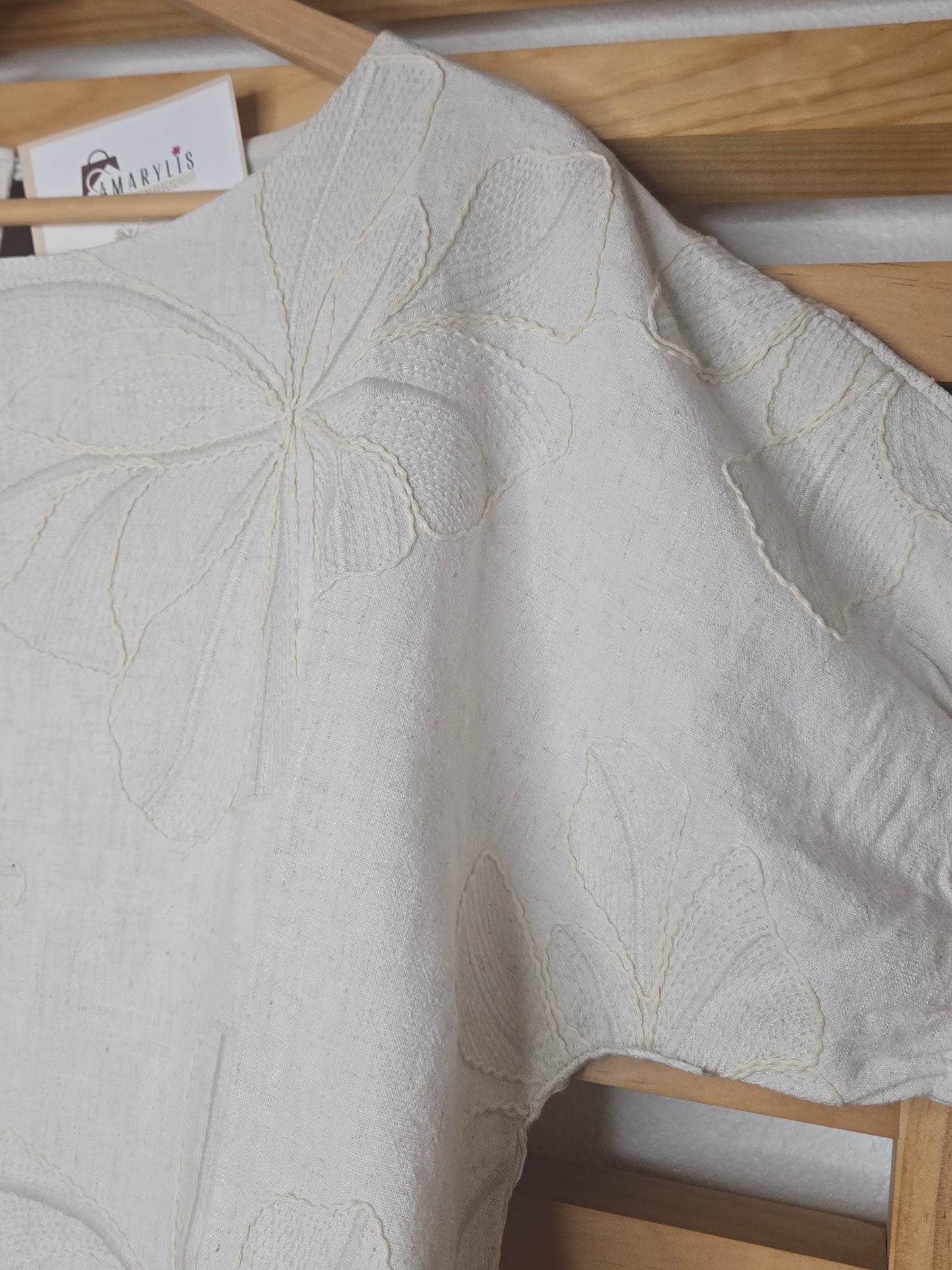 Beige linen-blend top with floral embroidery, featuring short dolman sleeves with elastic cuffs and a soft inner lining
