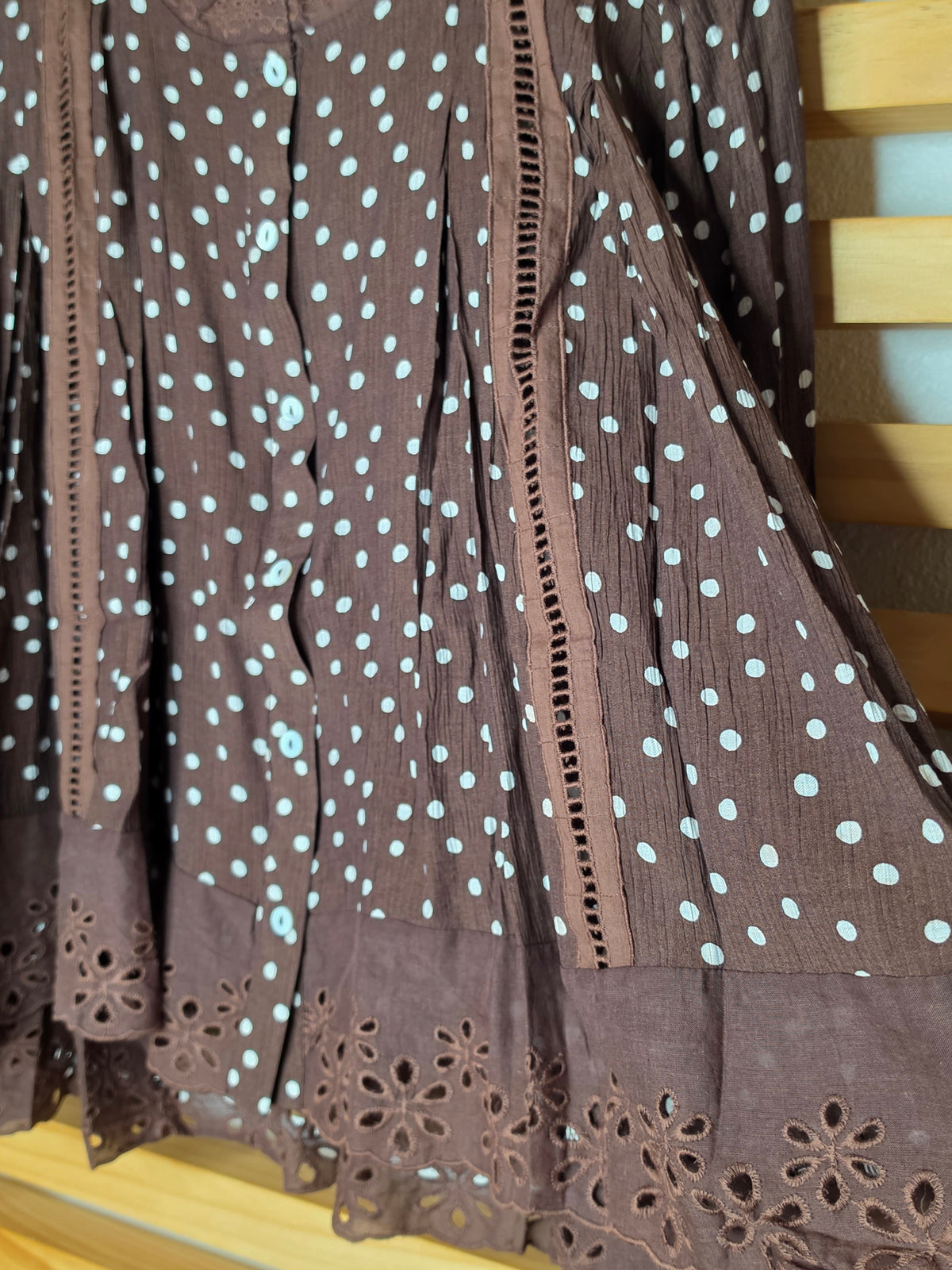 Women's polka dot blouse with scalloped lace neckline, vertical lace inserts, flowing sleeves, button-front closure, and wide eyelet lace hem