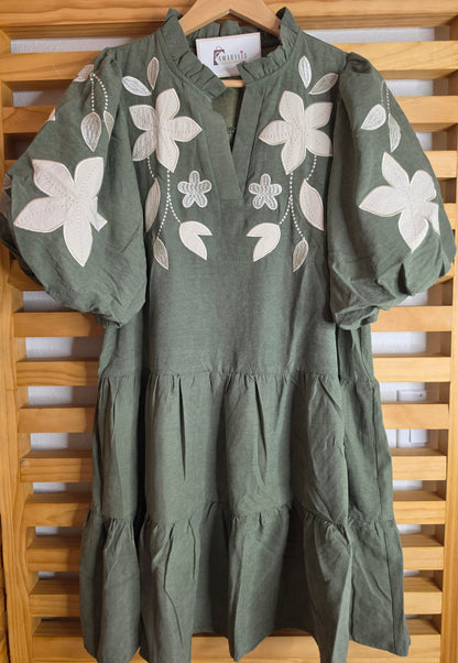 Olive boho dress with oversized floral embroidery, puff sleeves, tiered skirt, split neckline, and side pockets.
