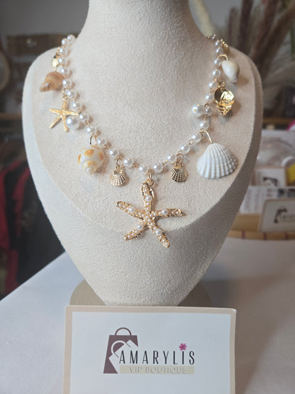 Pearl beaded necklace featuring shell charms, gold scallop accents, and a pearl embellished starfish pendant with an adjustable extender chain.