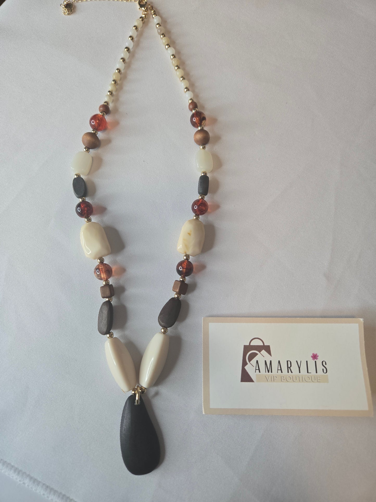 A timeless wood bead necklace with a graceful teardrop pendant, designed to bring natural beauty and effortless elegance to your wardrobe.
