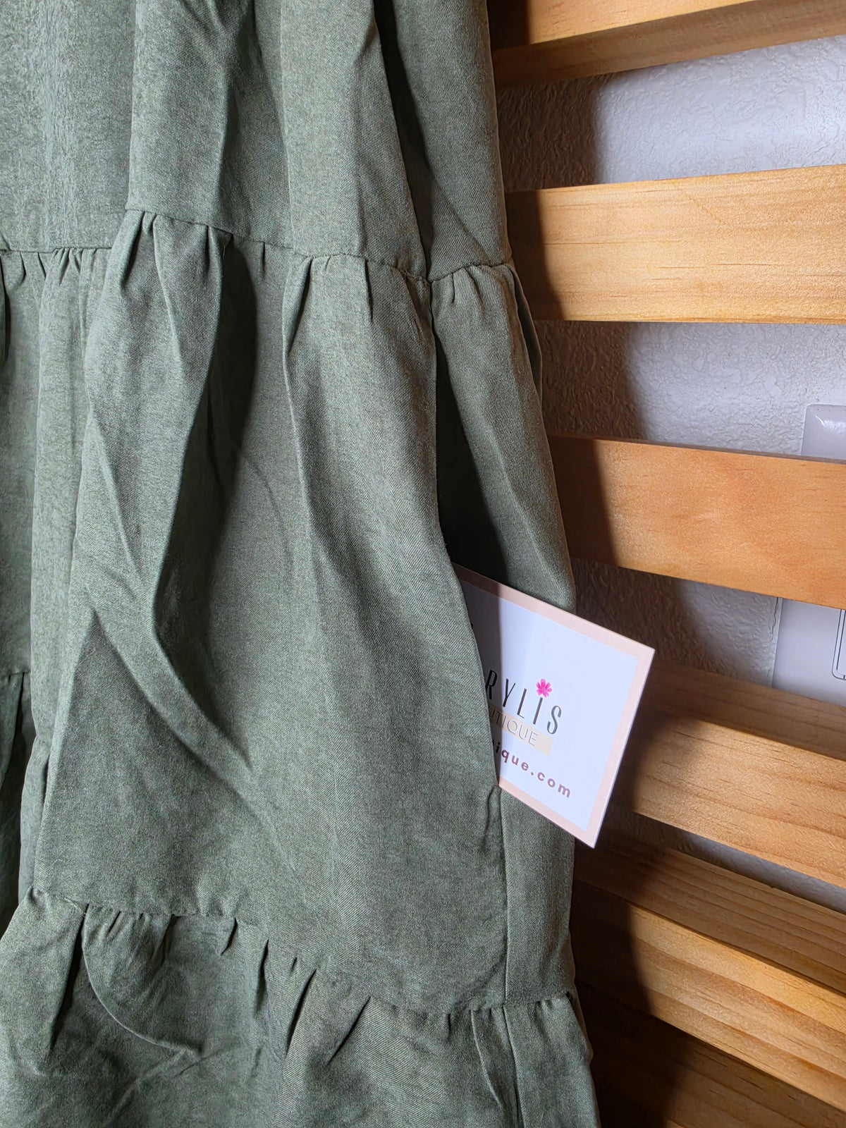 Olive boho dress with oversized floral embroidery, puff sleeves, tiered skirt, split neckline, and side pockets.
