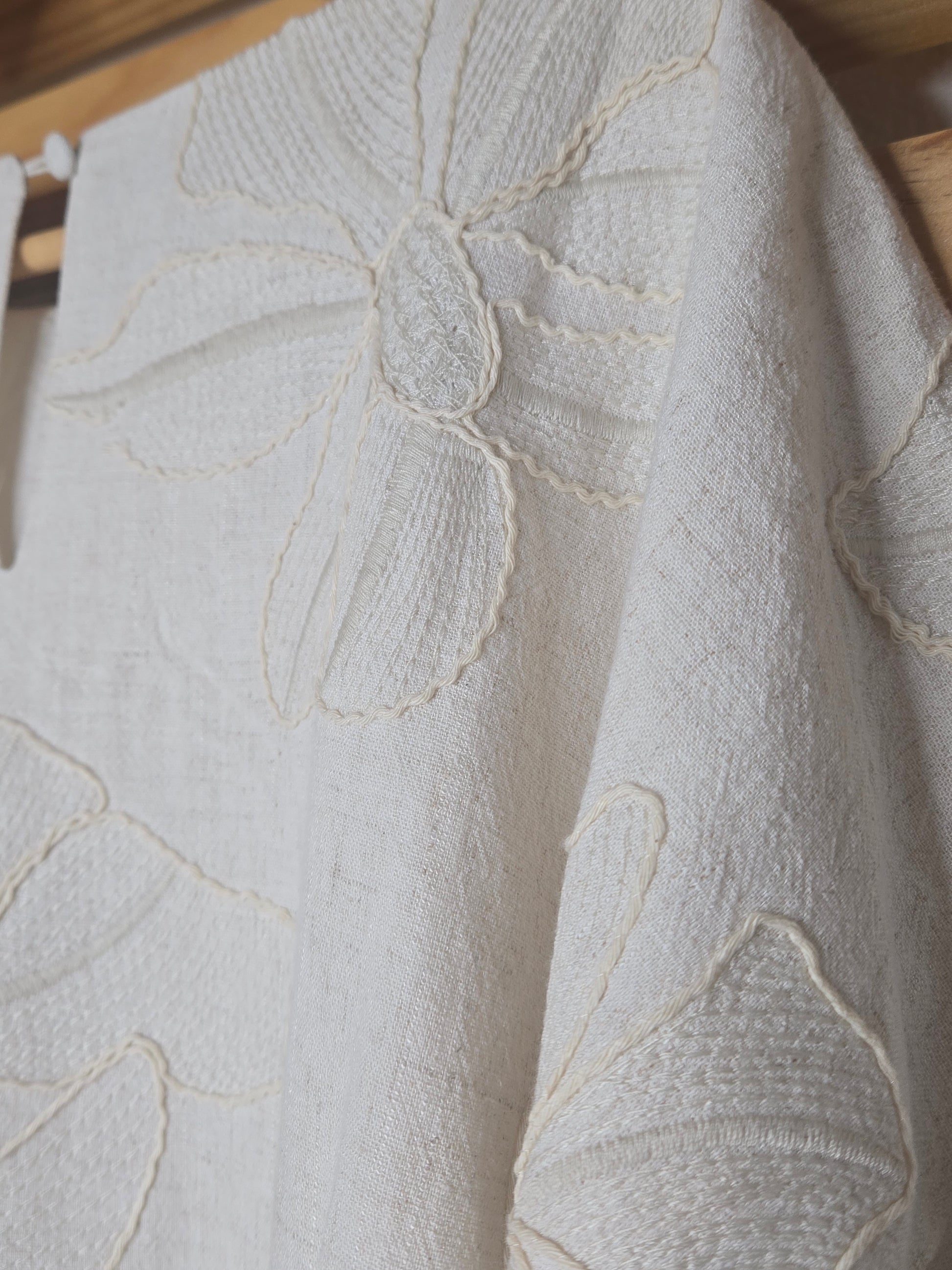 Beige linen-blend top with floral embroidery, featuring short dolman sleeves with elastic cuffs and a soft inner lining