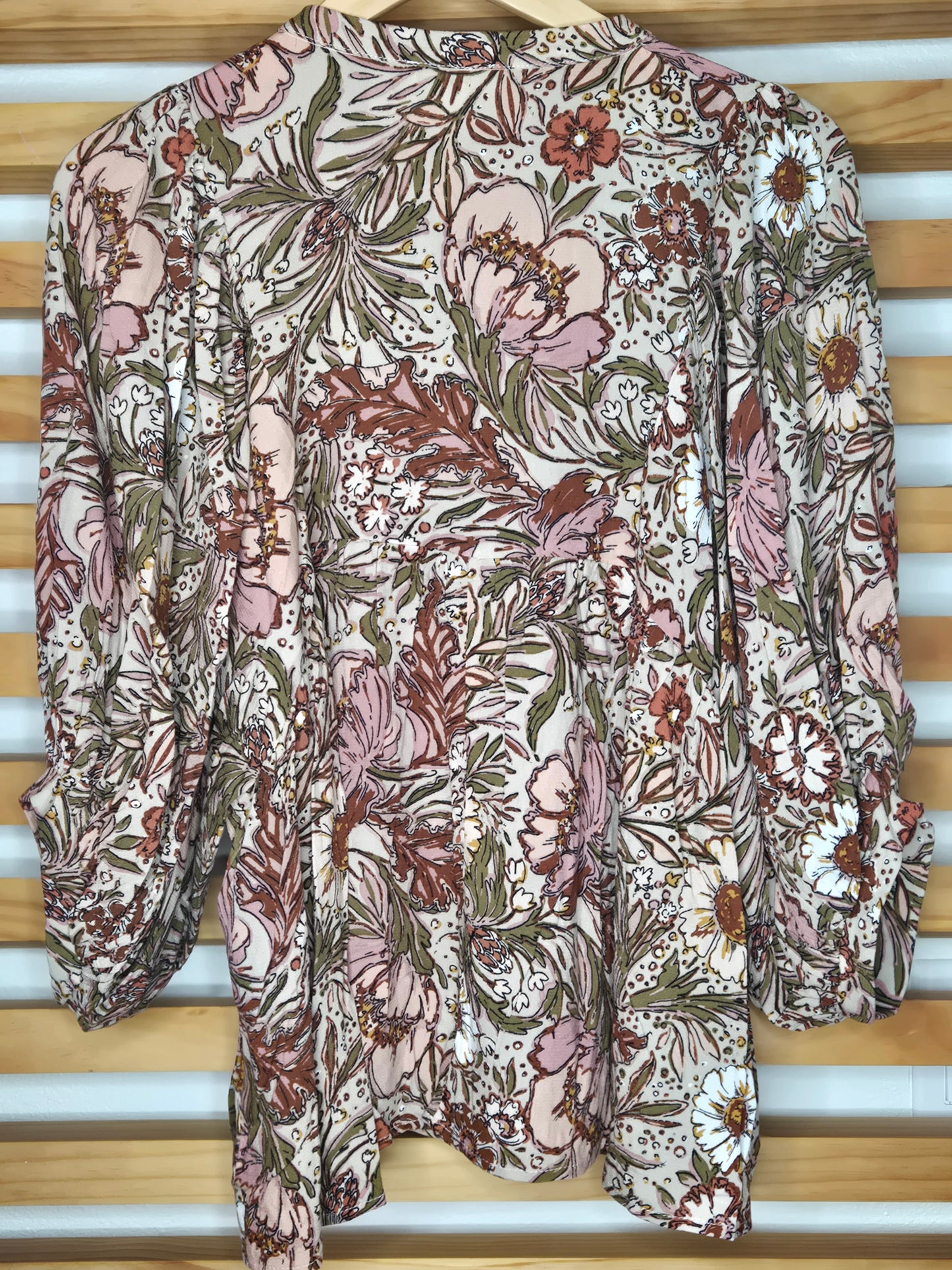 Soft and feminine peasant-style blouse featuring a delicate floral print, 3/4 length puff sleeves, and a tassel-tie neckline. Designed for effortless bohemian