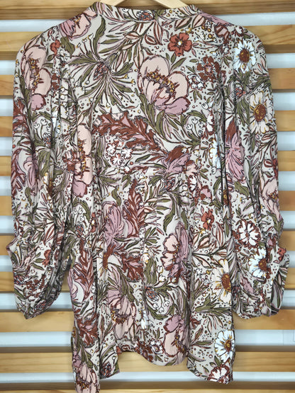 Soft and feminine peasant-style blouse featuring a delicate floral print, 3/4 length puff sleeves, and a tassel-tie neckline. Designed for effortless bohemian