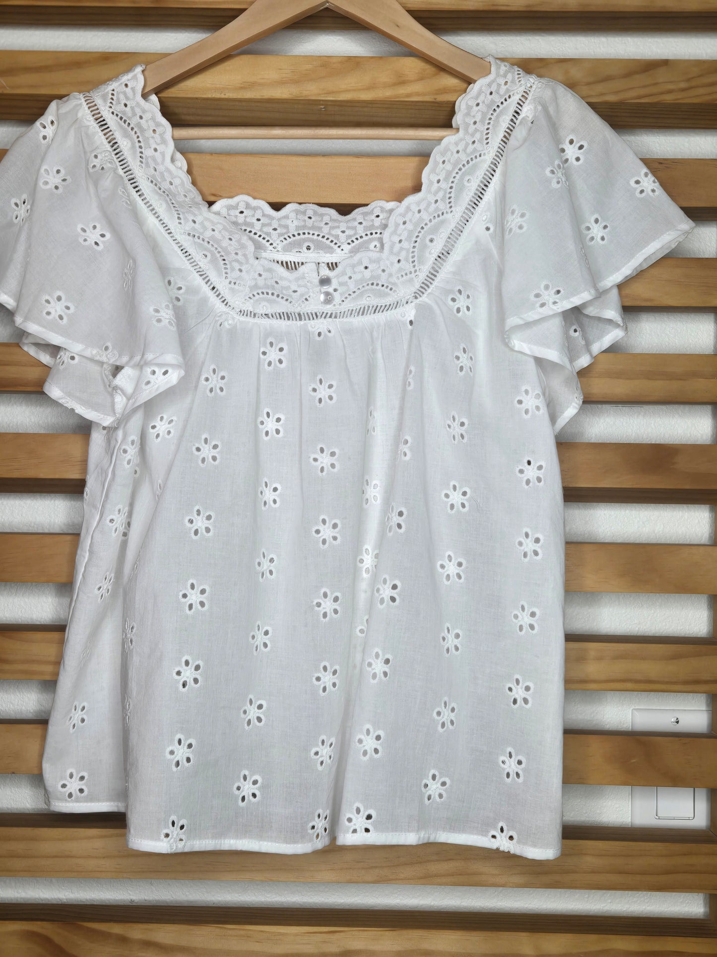 Eyelet white shirt and blue jeans walking through a clothing store with 'Amaryllis' branding.