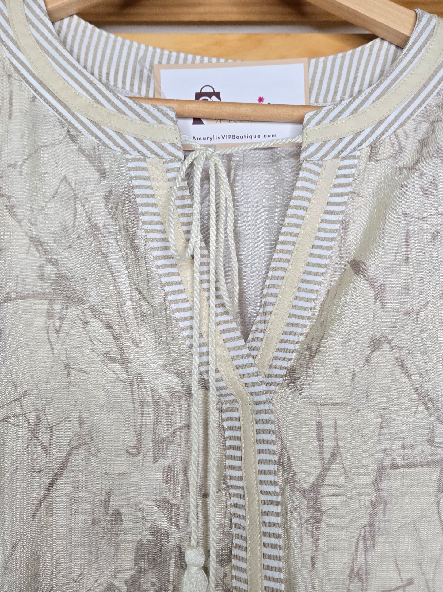Relaxed peasant-style blouse with subtle camouflage print, tasseled neckline and soft puff sleeves.