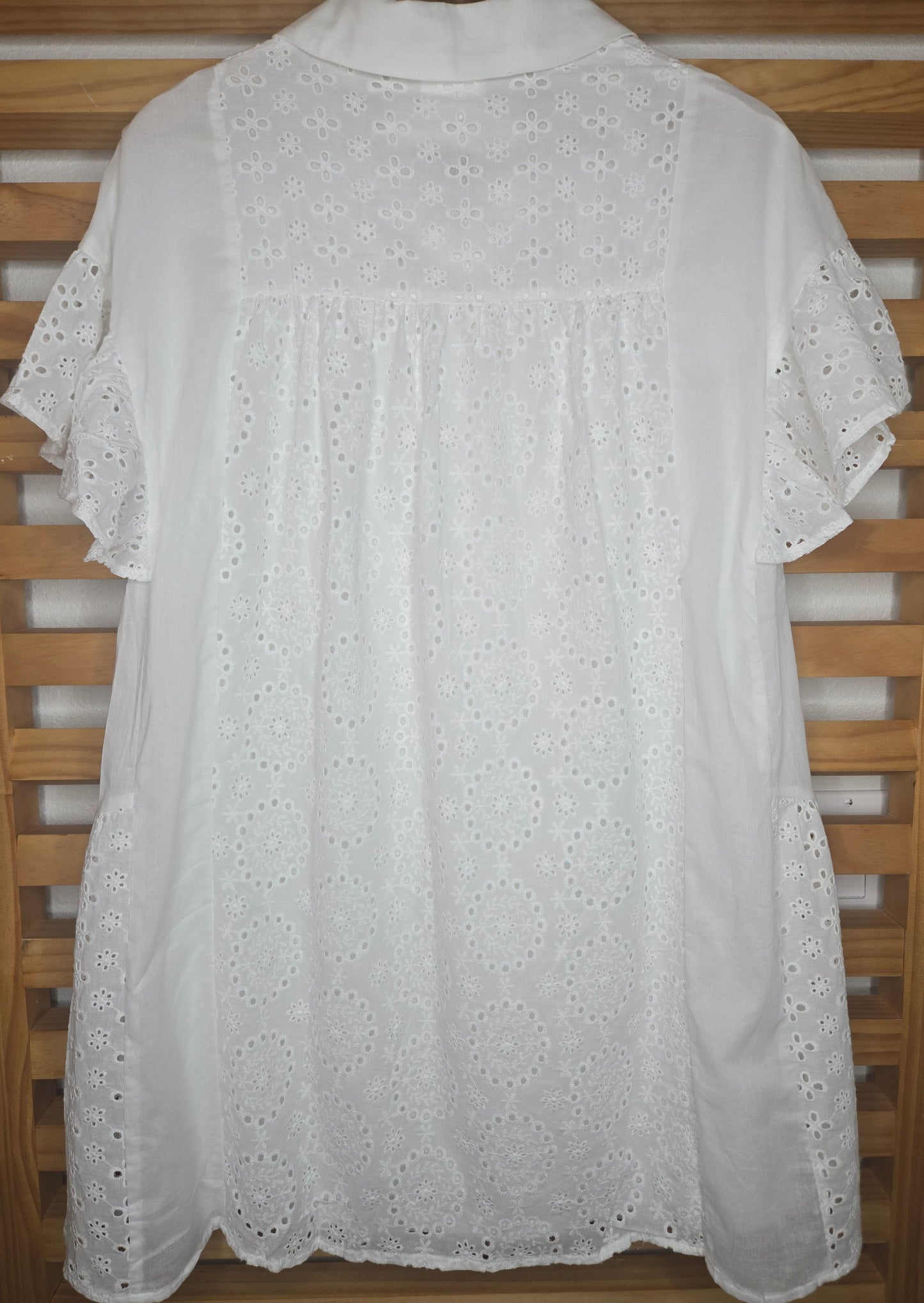 Lightweight shirt dress with eyelet embroidery, button-front closure, short flutter sleeves, and a soft, feminine silhouette.