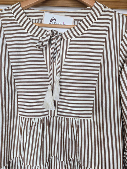 Lightweight cotton dress featuring classic color chocolate stripes, flowy bell sleeves, and a tassel tie neckline for a relaxed boho-inspired look. The loose silhouette offers comfort and movement, while the side pockets add everyday practicality. A charming and feminine piece that’s perfect for casual days or relaxed outings