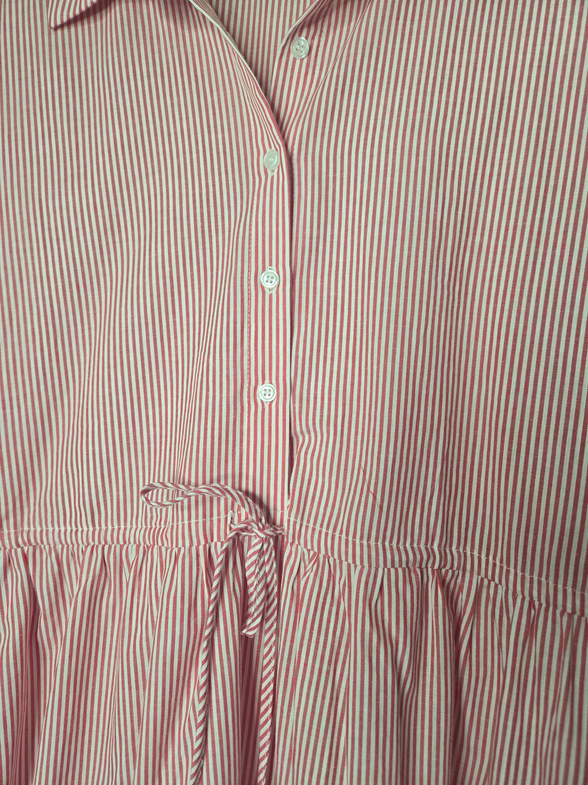 Red striped cotton dress with collared neckline, rolled short sleeves, button front detail, tiered skirt, ruffled hem, and adjustable tie waist.