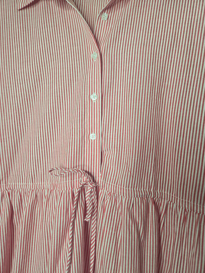 Red striped cotton dress with collared neckline, rolled short sleeves, button front detail, tiered skirt, ruffled hem, and adjustable tie waist.