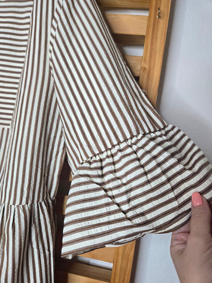 Lightweight cotton dress featuring classic color chocolate stripes, flowy bell sleeves, and a tassel tie neckline for a relaxed boho-inspired look. The loose silhouette offers comfort and movement, while the side pockets add everyday practicality. A charming and feminine piece that’s perfect for casual days or relaxed outings
