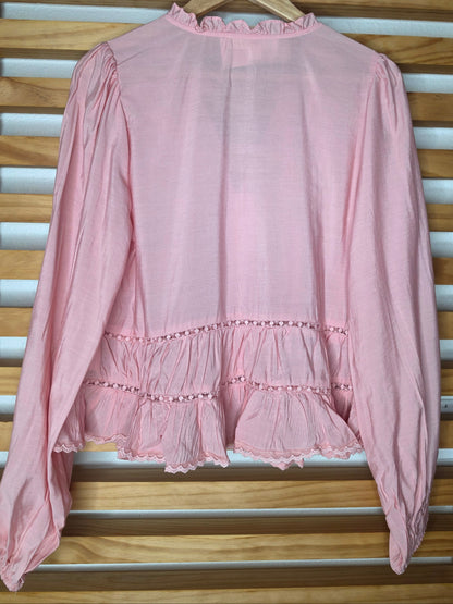 Women’s white blouse with V-neckline, button front, lace-trimmed ruffles, delicate pin-tuck details, and long balloon sleeves with elastic cuffs.