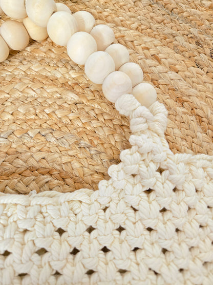 Large woven macrame tote bag with intricate knotted design, long fringe trim, and braided shoulder strap.