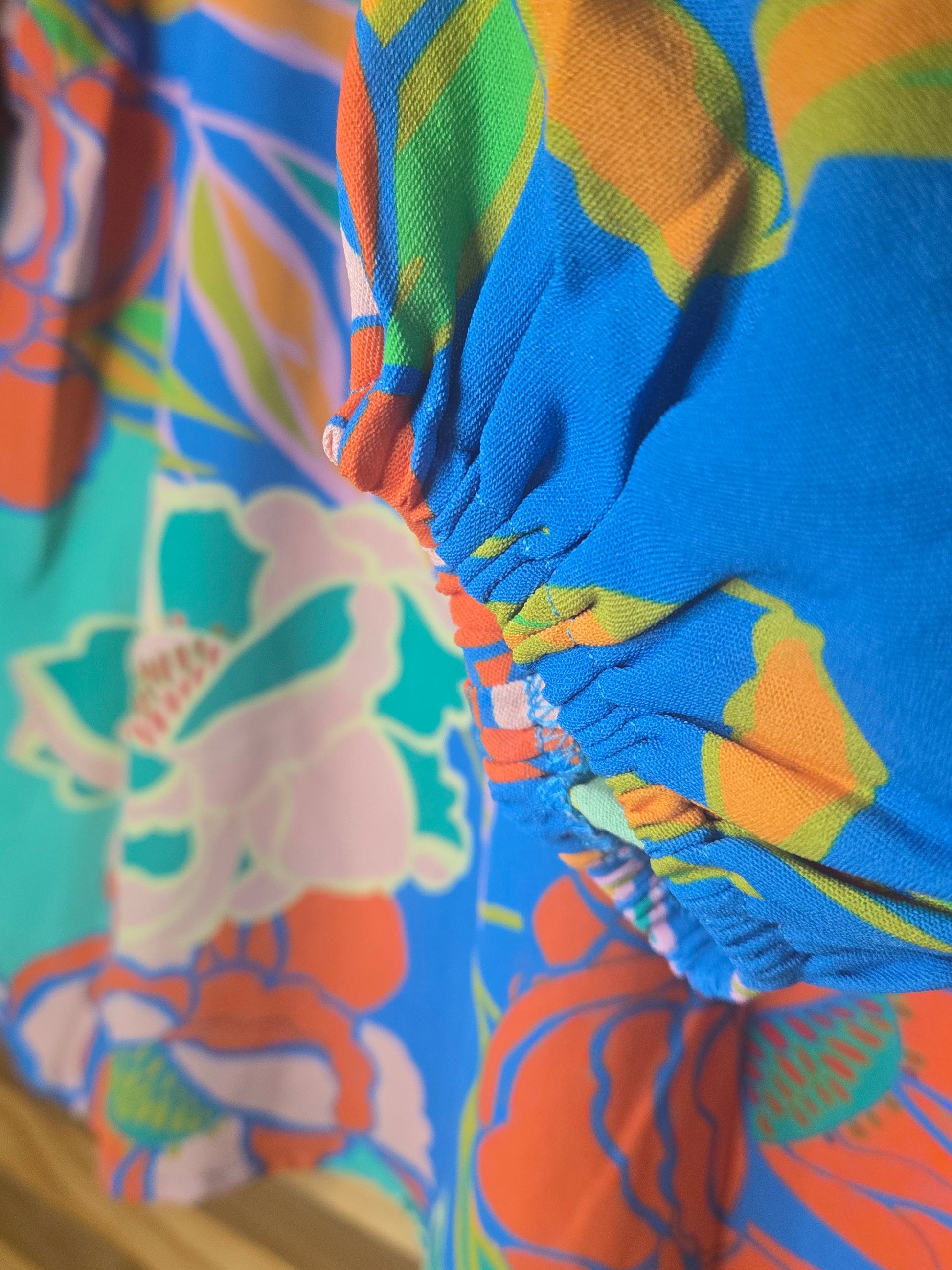 Floral printed blouse featuring 3/4 sleeves and a soft ruffled neckline detail.