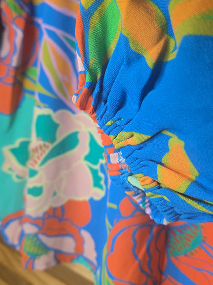 Floral printed blouse featuring 3/4 sleeves and a soft ruffled neckline detail.