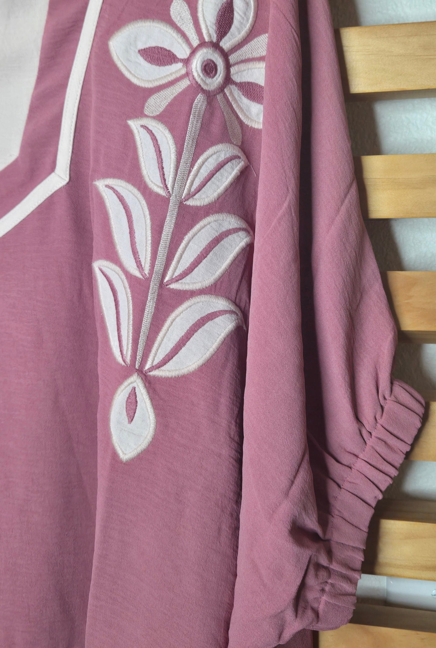 Women's dusty rose embroidered blouse featuring floral embroidery, contrast striped rib trim, short sleeves, and a relaxed fit.