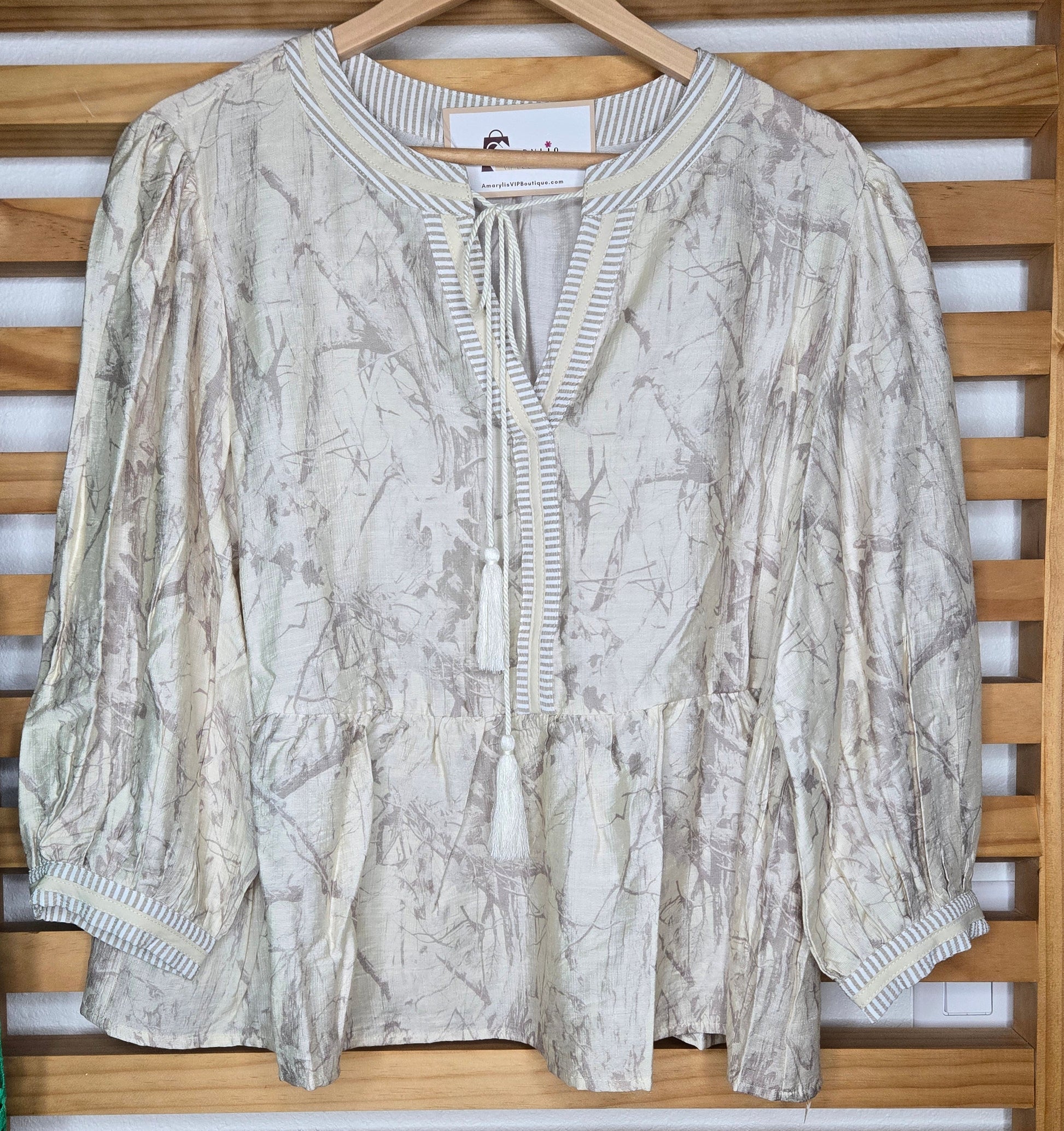 Relaxed peasant-style blouse with subtle camouflage print, tasseled neckline and soft puff sleeves.
