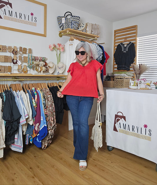 Woman in a red shirt and blue jeans walking through a clothing store with 'Amaryllis' branding.