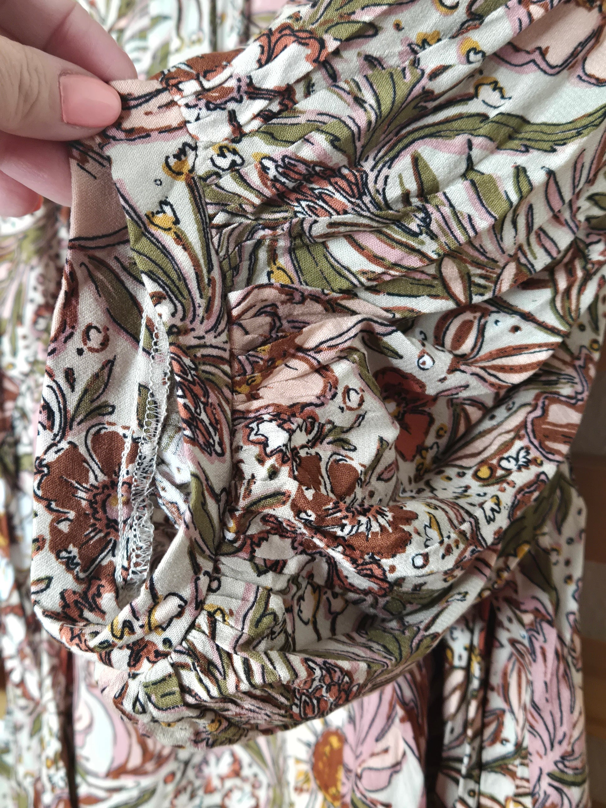 Soft and feminine peasant-style blouse featuring a delicate floral print, 3/4 length puff sleeves, and a tassel-tie neckline. Designed for effortless bohemian