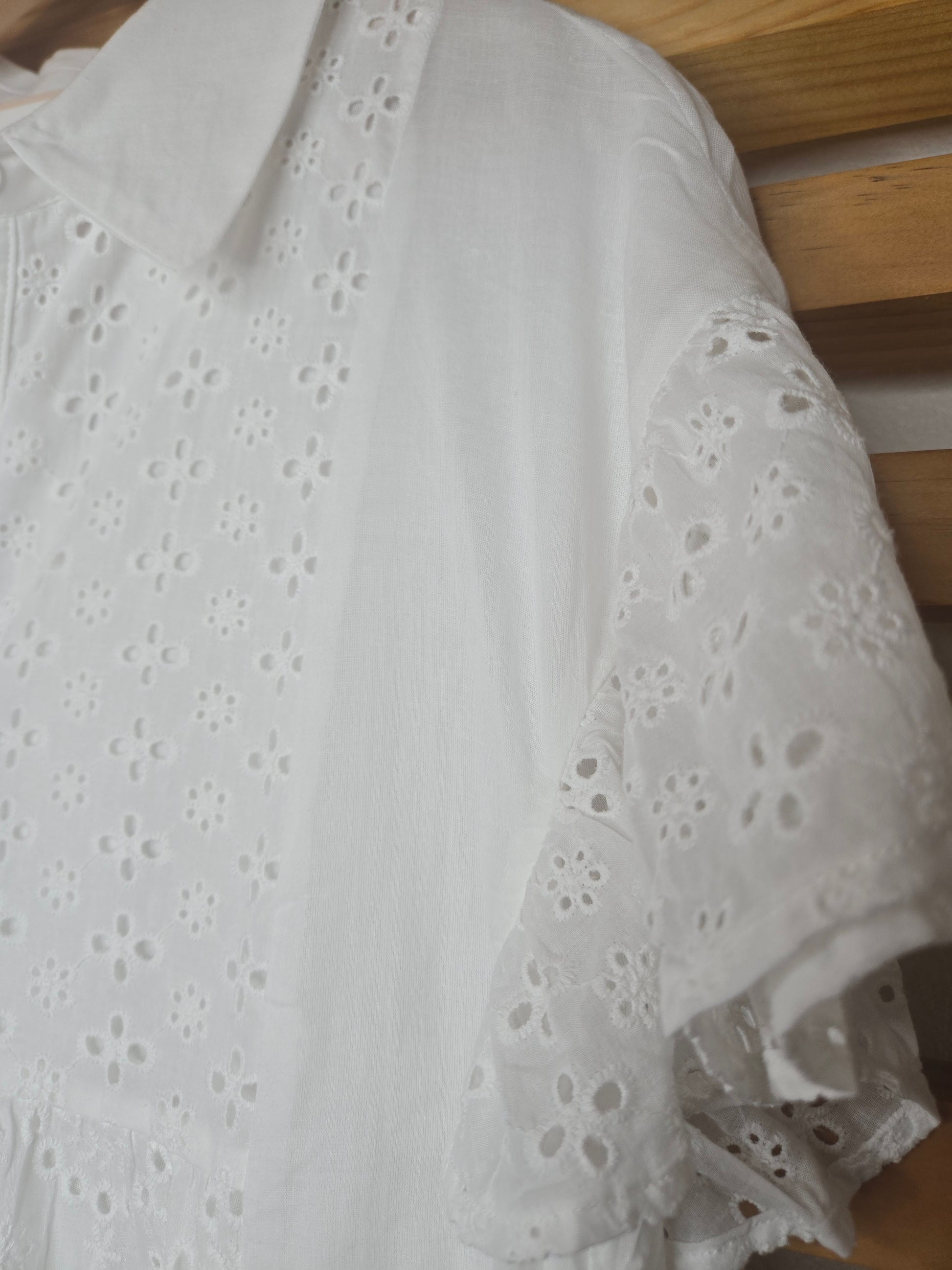Lightweight shirt dress with eyelet embroidery, button-front closure, short flutter sleeves, and a soft, feminine silhouette.
