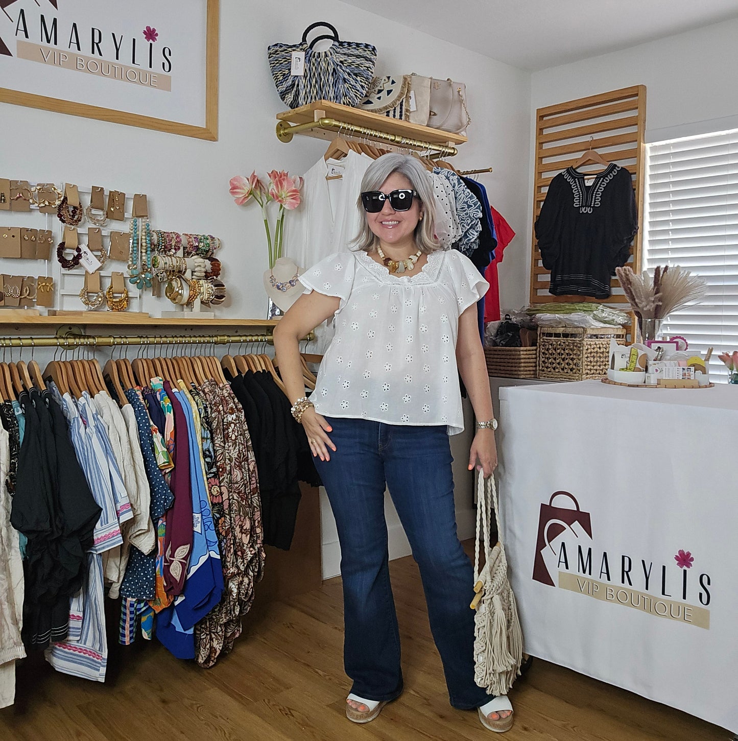 Woman in white shirt and blue jeans walking through a clothing store with 'Amaryllis' branding.